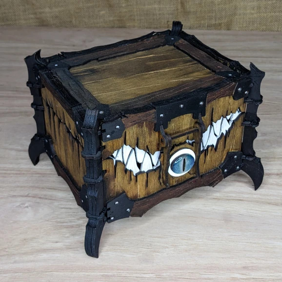 Fantasy-themed wooden mimic chest with eye and fang details, handcrafted for collectors and game night flair.